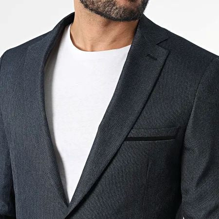 Détail du revers et de la poche poitrine à liseré noir du blazer marine