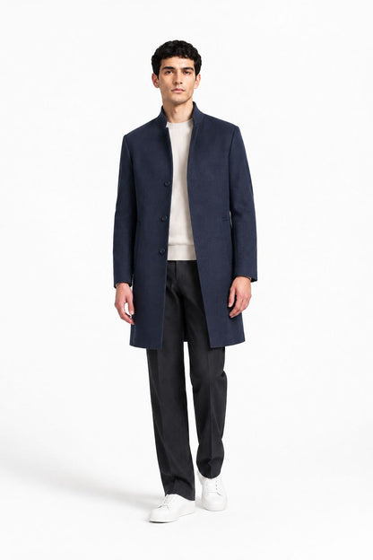 Manteau homme bleu marine mi-long porté avec pantalon habillé et baskets blanches