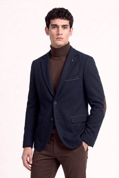 Blazer homme bleu marine en chenille à coudières chocolat porté avec un col roulé et un pantalon marron