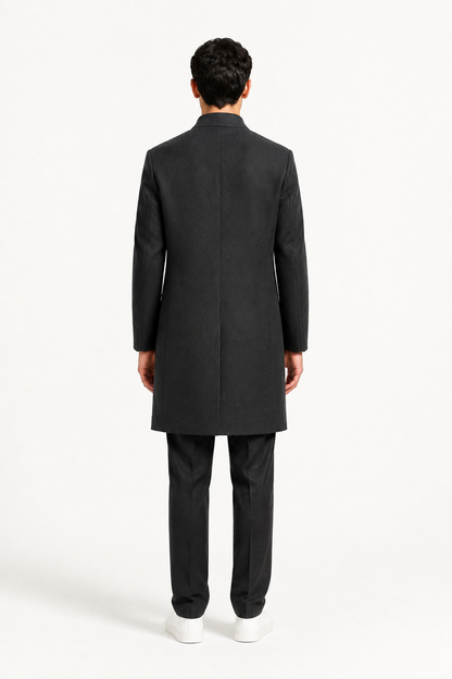 Dos du manteau homme noir mi-long porté avec pantalon habillé
